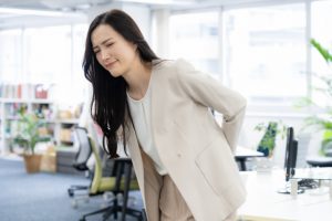 腰が痛くて曲げられない女性